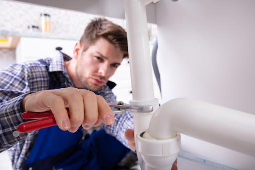 A plumber performing a service on a drain.